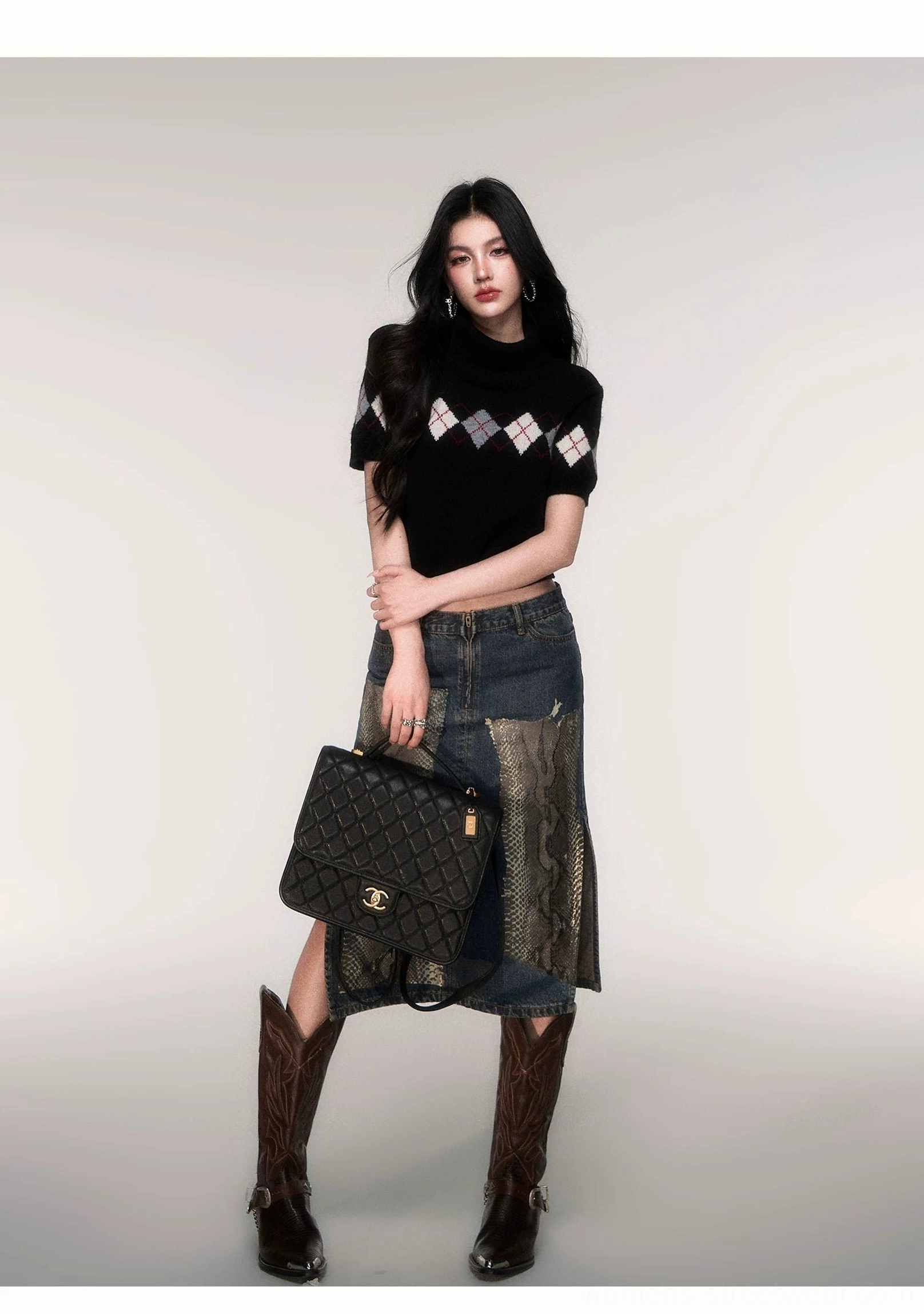 Retro Y2K streetwear outfit with a black argyle cropped sweater, patchwork denim midi skirt, cowboy boots, and quilted leather handbag
