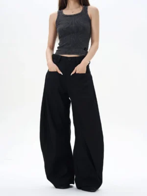 Front full-body view of black high-waisted wide-leg palazzo streetwear pants with an oversized curved silhouette on a female model