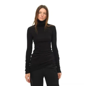 Black slim fit turtleneck long sleeve knit top with draped waist hem and straight black trousers
