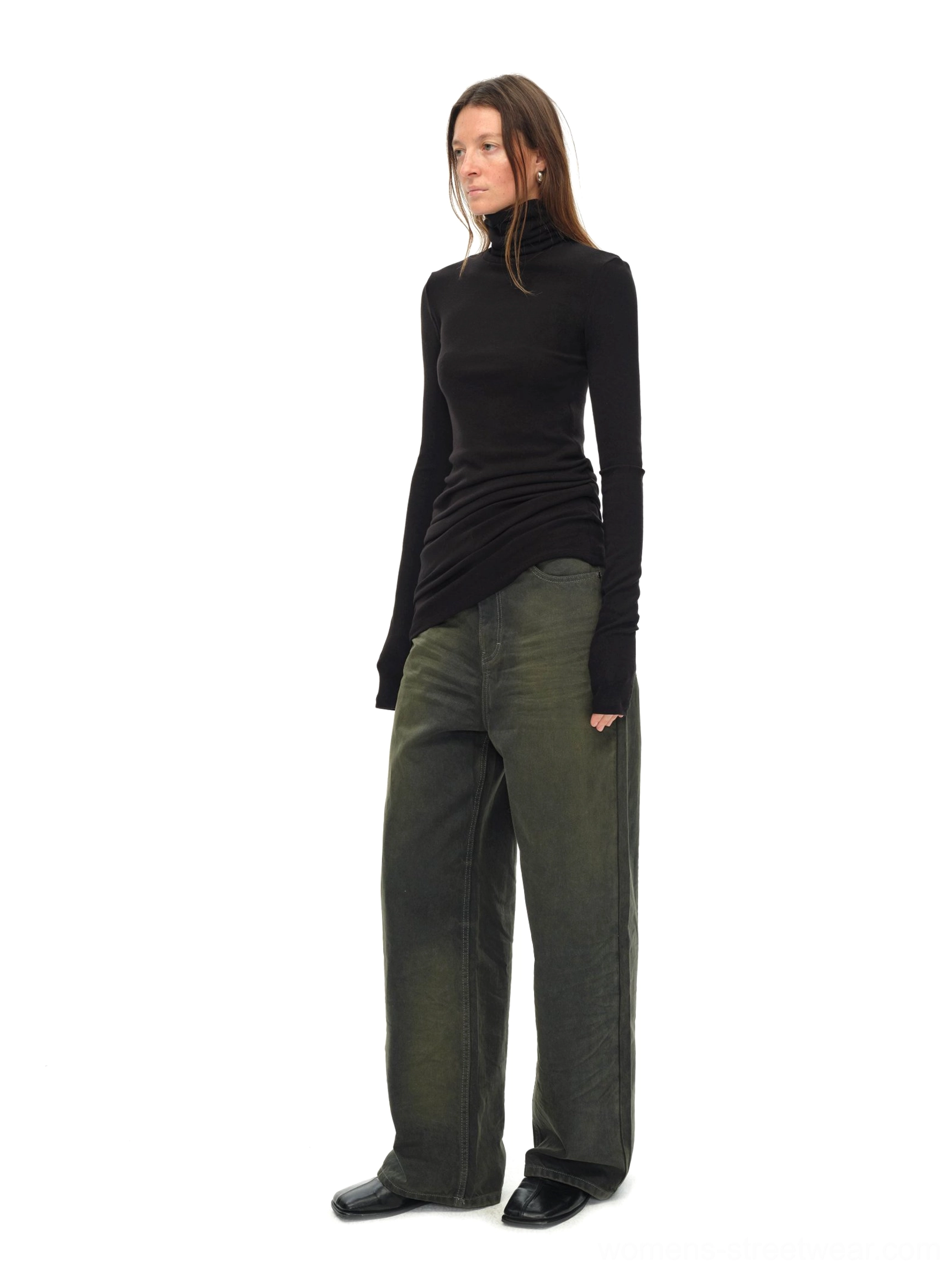 Side view of black asymmetric draped turtleneck knit top styled with vintage green wide-leg jeans