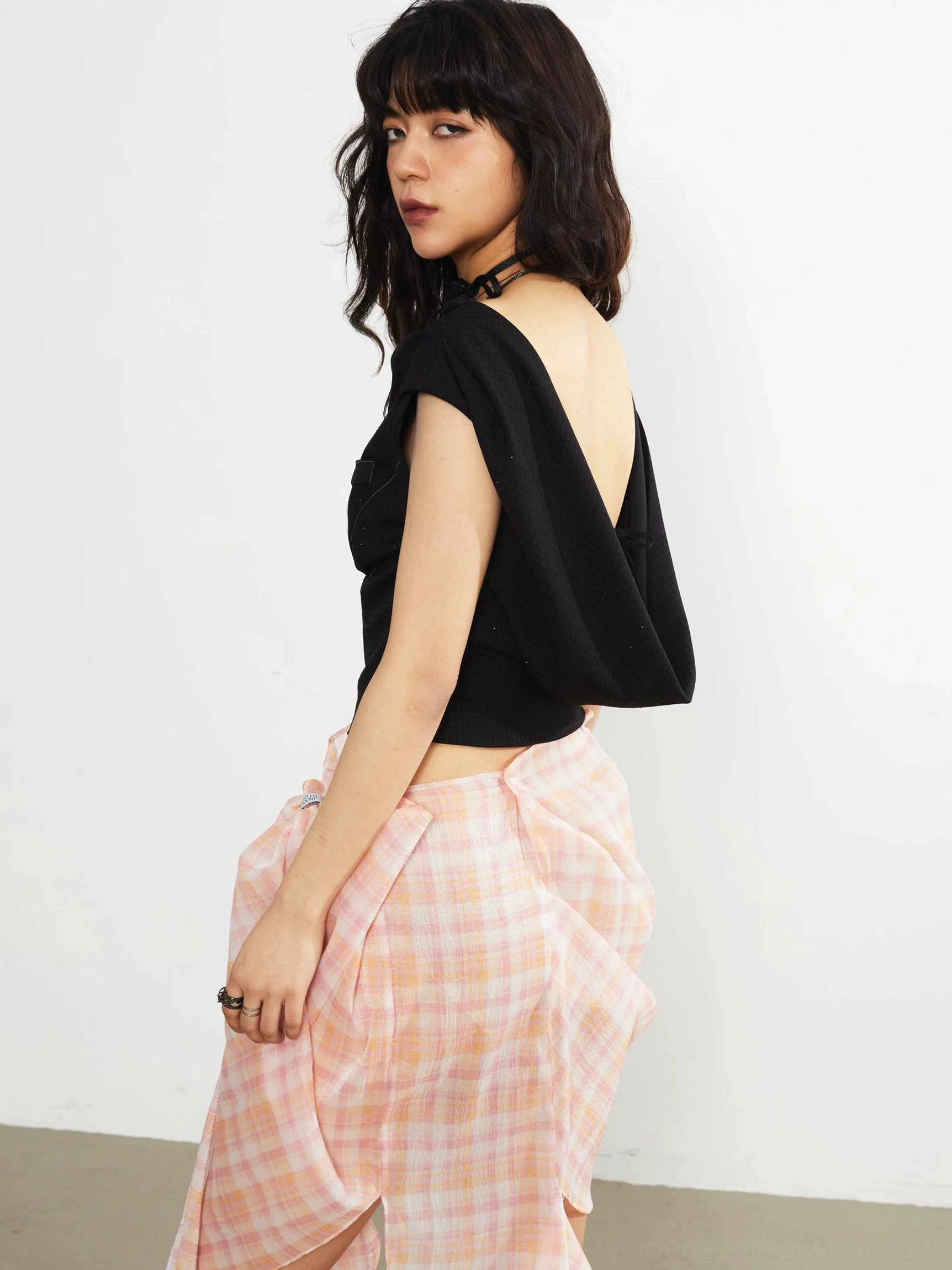 Black asymmetric knit crop top three-quarter back view with low draped open back fitted waist and tie detail