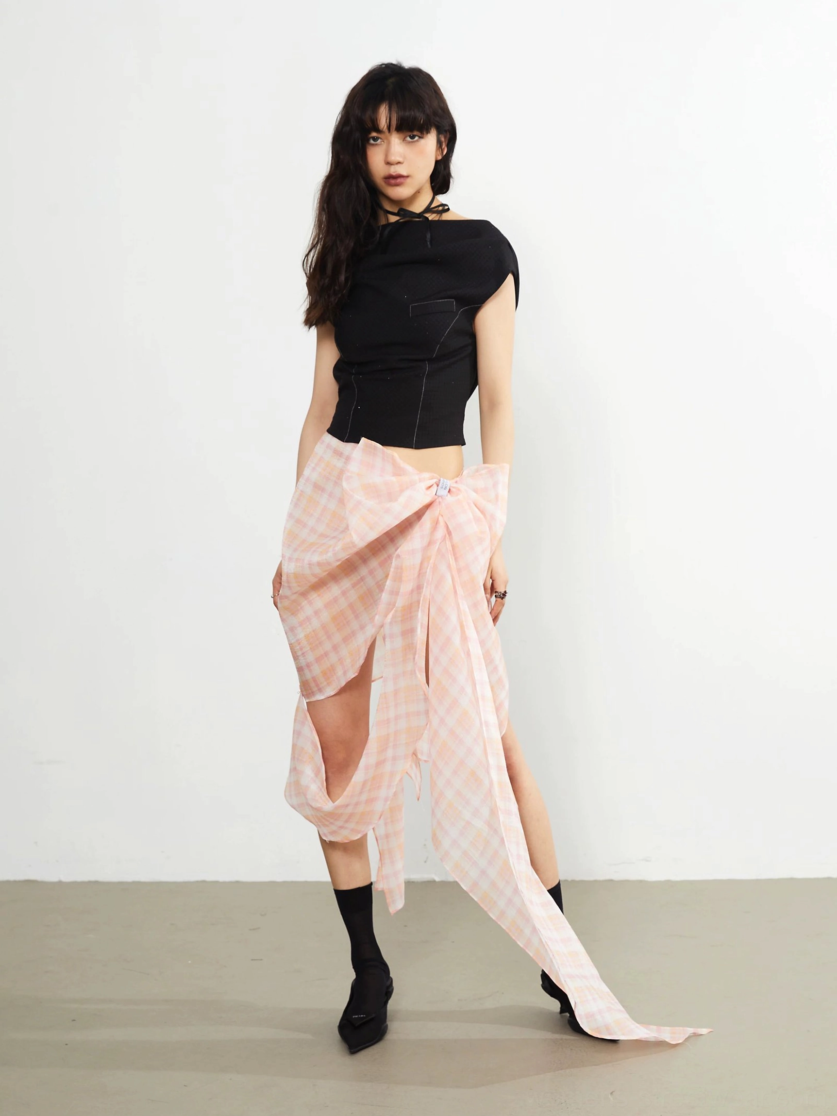 Black asymmetric knit crop top full body side styling with pink plaid wrap skirt ankle socks and block heels