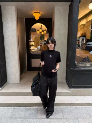 Black asymmetric mock neck sigil tee worn with black wide-leg trousers in an avant-garde streetwear outfit