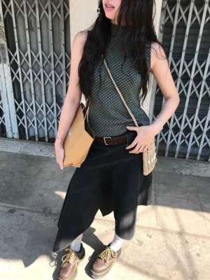 Black asymmetric panel high-waist cotton midi skirt shown in a full-body outdoor streetwear look with an angled hem
