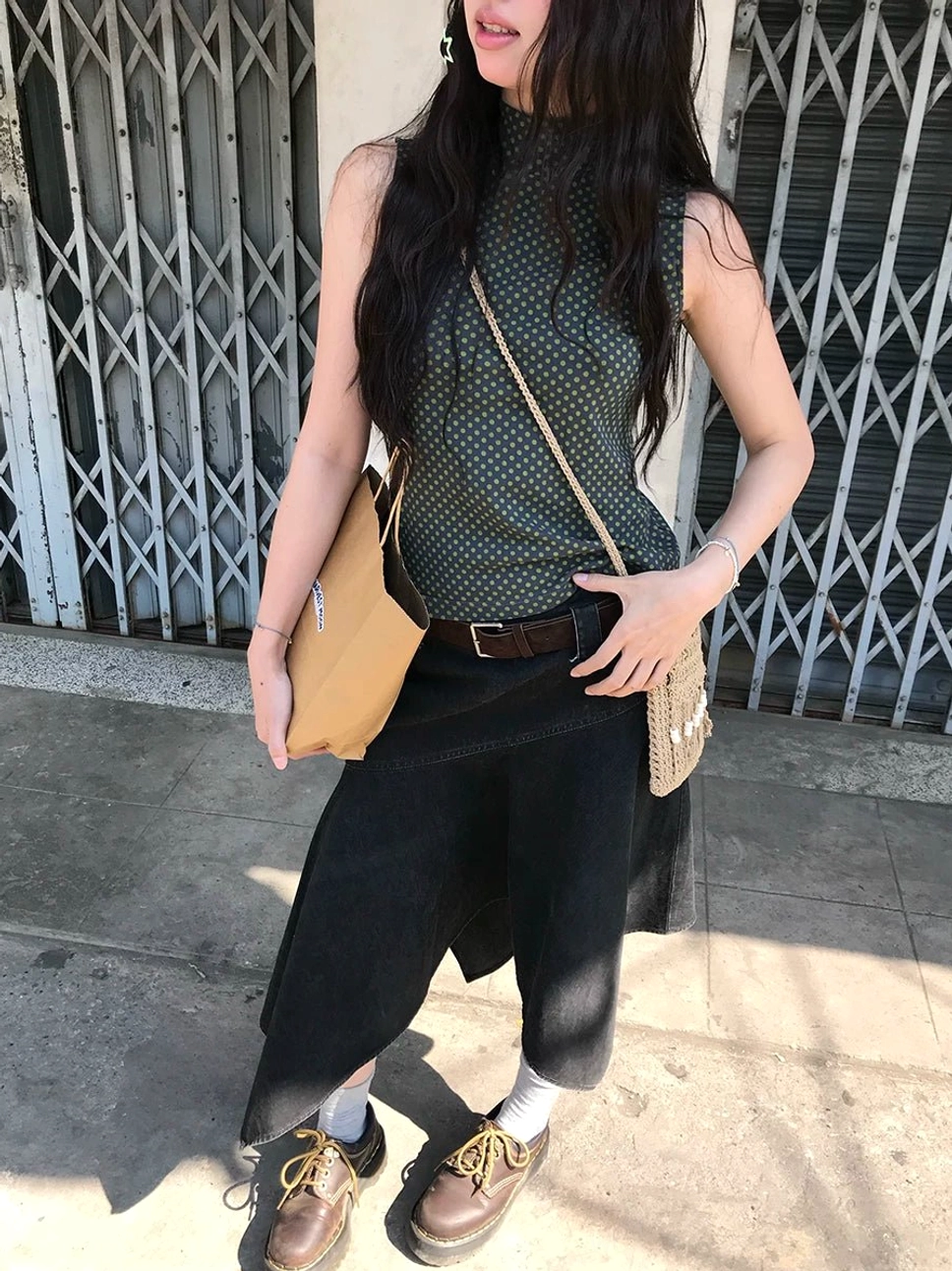 Black asymmetric panel high-waist cotton midi skirt shown in a full-body outdoor streetwear look with an angled hem