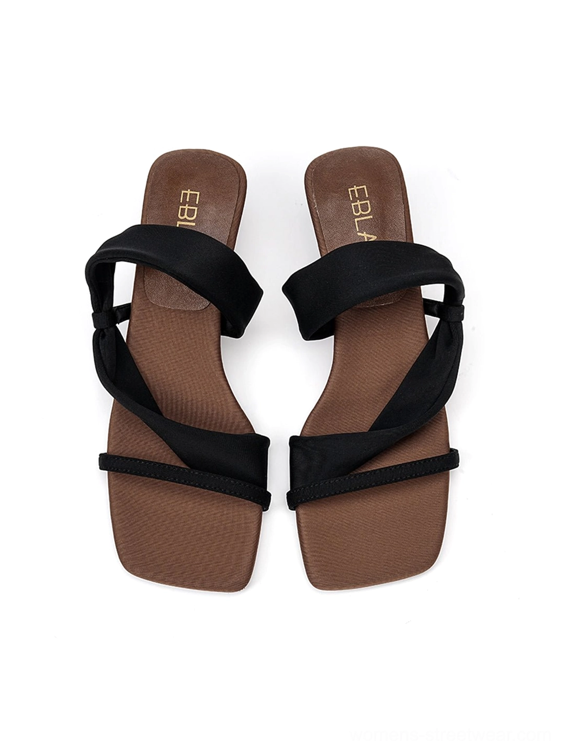 Pair of black asymmetric slide sandals showing crossed straps, open square toes, and contrasting brown insoles
