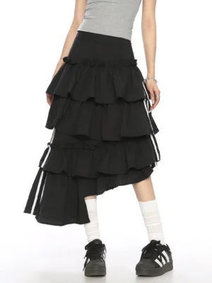 Black asymmetric tiered ruffle midi skirt with white striped ribbon ties styled with grey crop top and sneakers front three quarter view
