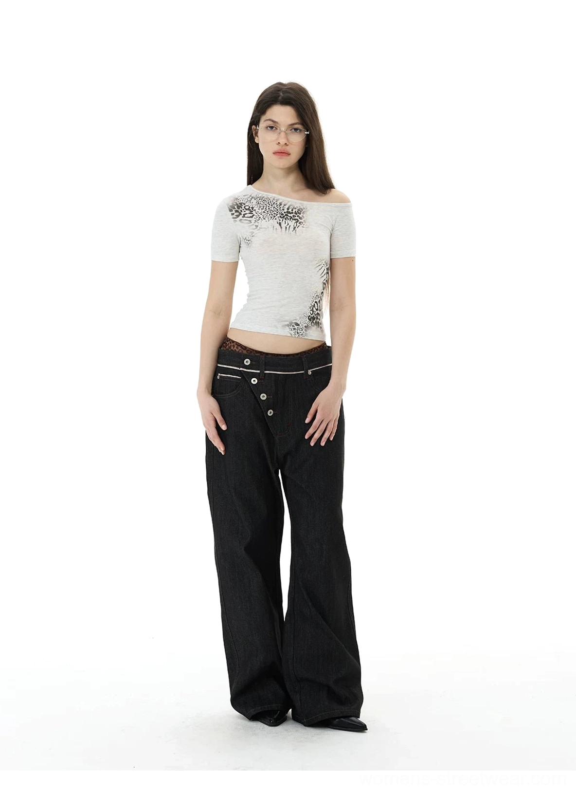 Front view of black asymmetric waist wide-leg streetwear jeans styled with an off-shoulder printed T-shirt