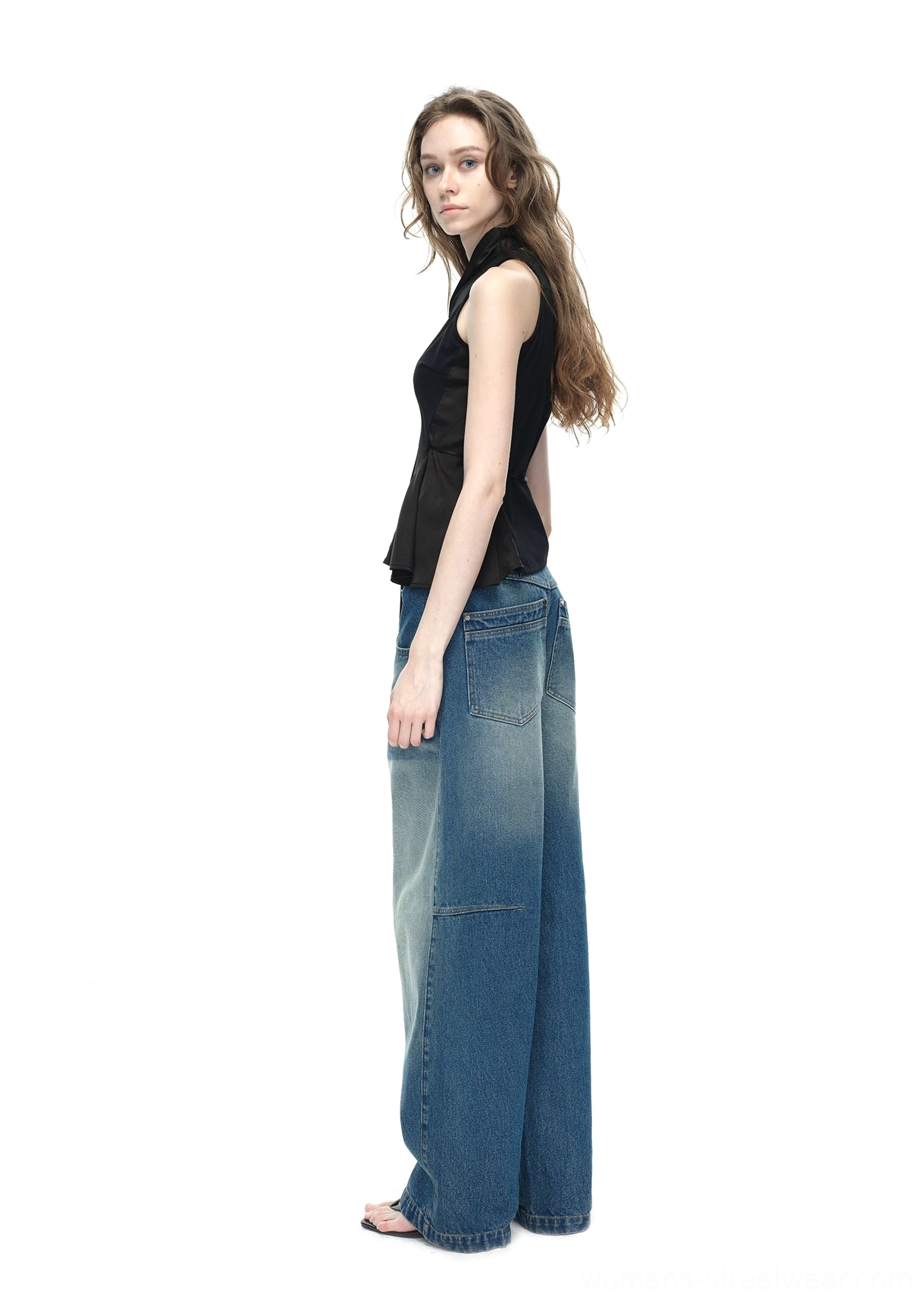 Black fitted asymmetrical halter top side view featuring sleeveless construction uneven hem and flowing adjustable side tie
