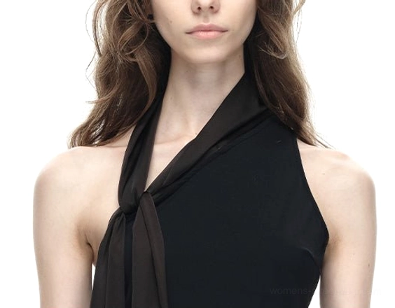Close-up of black asymmetrical halter top showing the smooth fabric knotted halter sash and draped asymmetric neckline