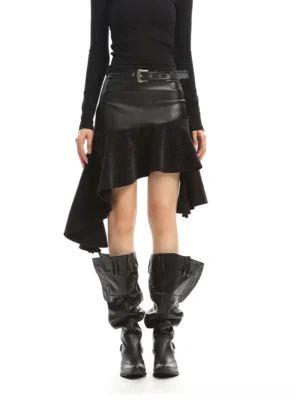 Full front view of black asymmetrical patchwork mini skirt styled with black long sleeve top and knee-high western boots