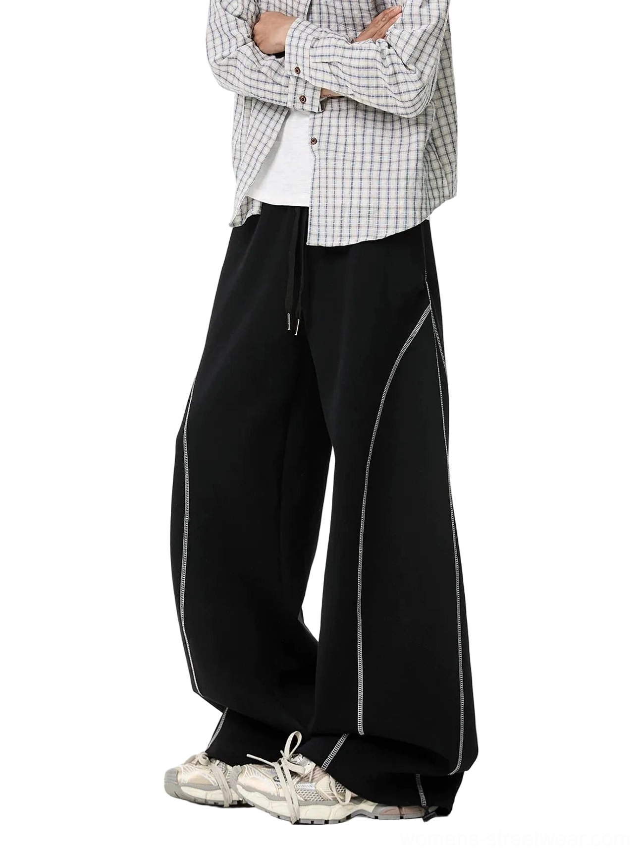 Side view of black oversized balloon sweatpants with dramatic puddling legs, contrast knee stitching, drawstring waist, and modern urban streetwear styling