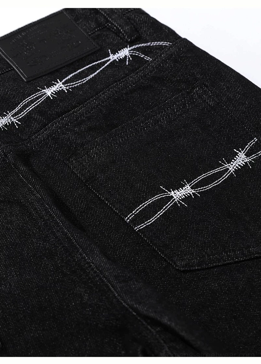 Close-up rear waistband and pockets of black barbed wire embroidered wide leg flare jeans