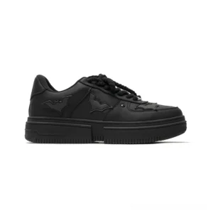Side profile of black bat crest platform sneakers with matte upper, wing applique details, rope laces, and thick streetwear sole