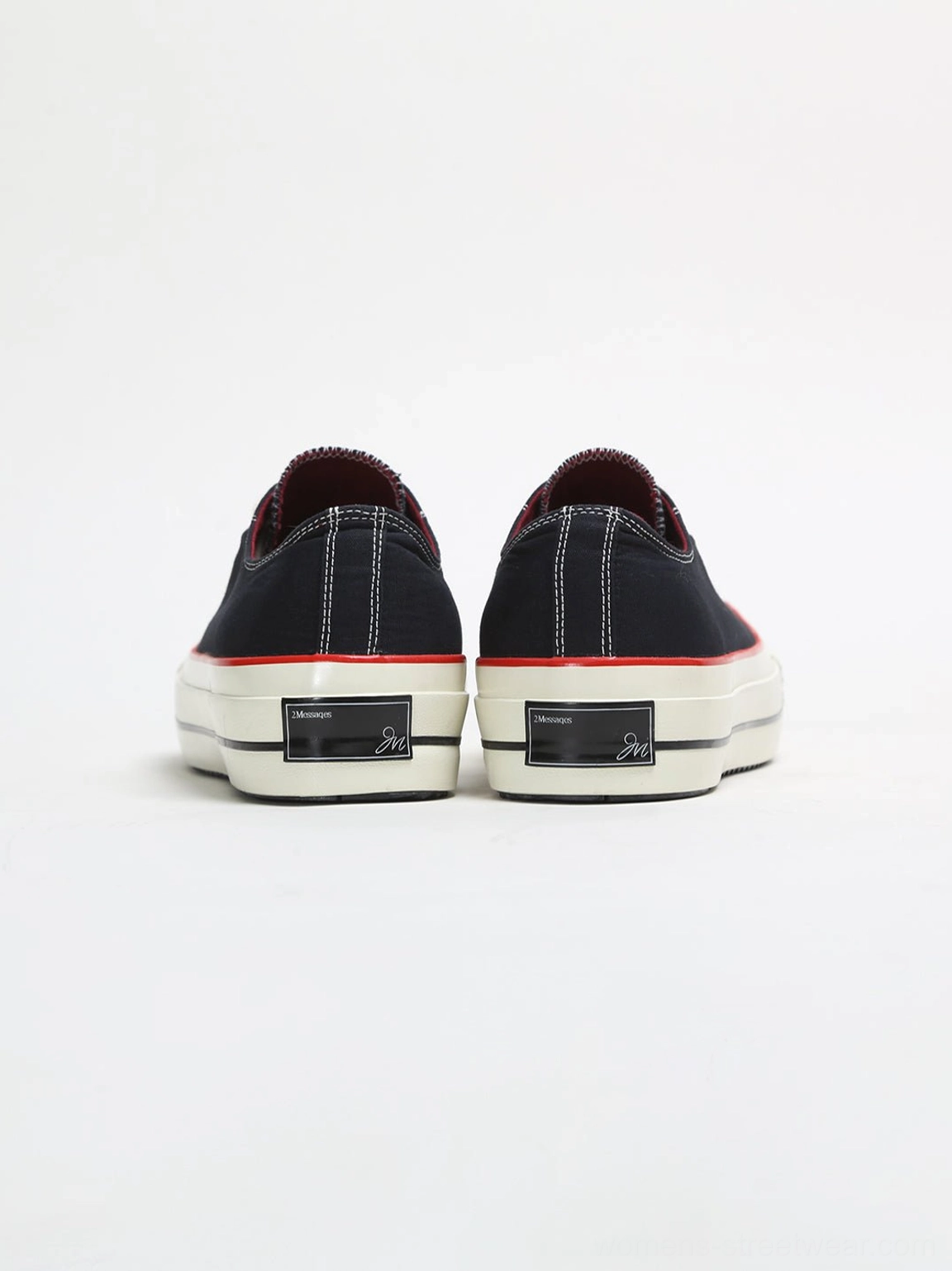 Rear view of black bat print platform canvas sneakers with thick off-white midsoles, red trim line, and metal heel plaques