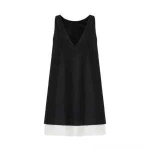 Close-up view of a minimalist black color-block shift dress featuring a smooth matte woven shell, deep V neckline, and ivory contrast layer