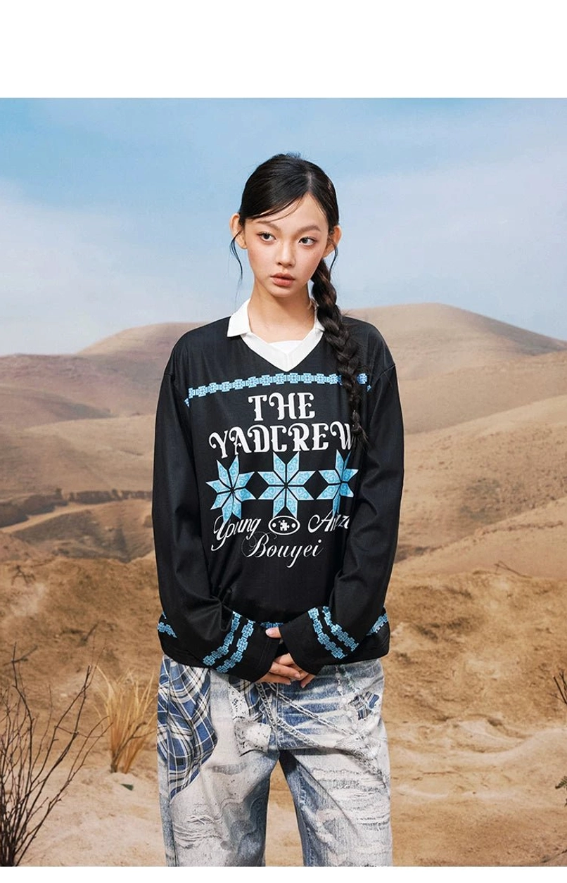 Black oversized collared long sleeve streetwear graphic shirt shown from the front with blue geometric snowflake prints and contrast sleeve trim