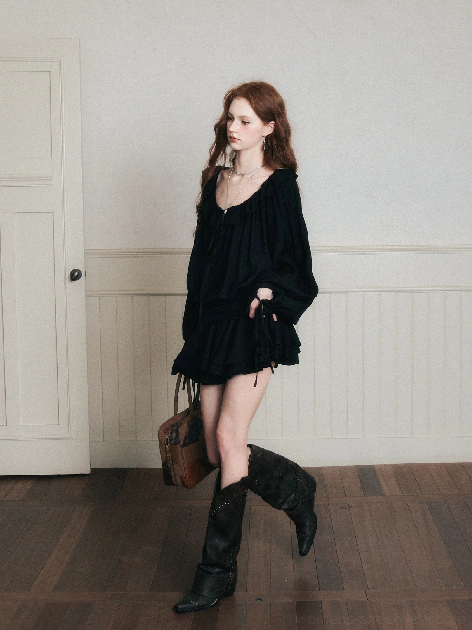Walking side view of black boho gothic ruffle poet mini dress set with loose silhouette and brown vintage handbag