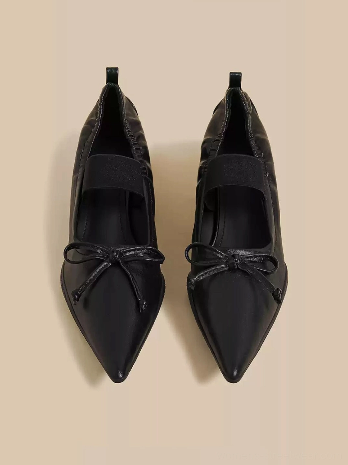 Top view of black bow pointed-toe Mary Jane mules with elastic straps and open mule backs
