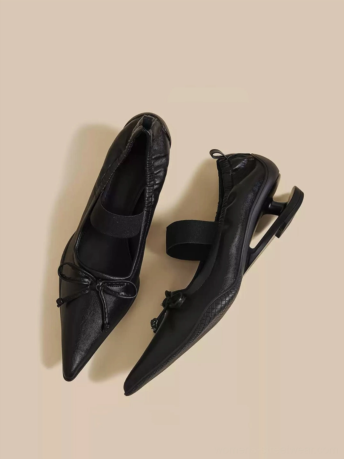 Black bow pointed-toe mules showing the sculpted curved heel and streamlined Mary Jane silhouette
