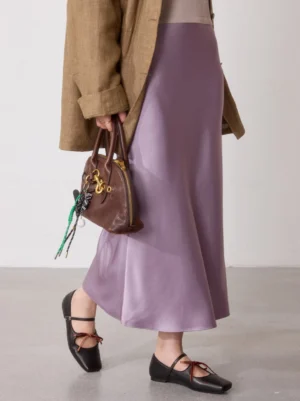 Black bow ballet flats styled with a brown blazer, lavender satin skirt, and brown handbag in a polished streetwear outfit