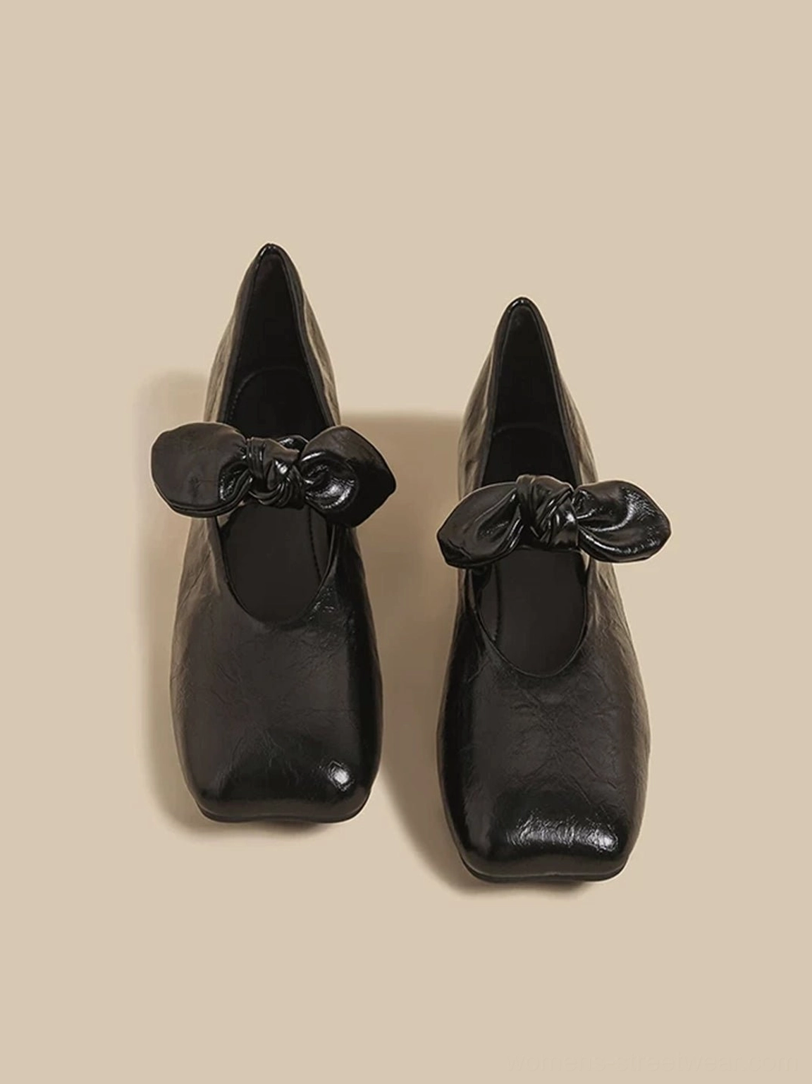 Pair of black bow square-toe flats shown from above with padded bow strap, textured upper, and low rubber sole