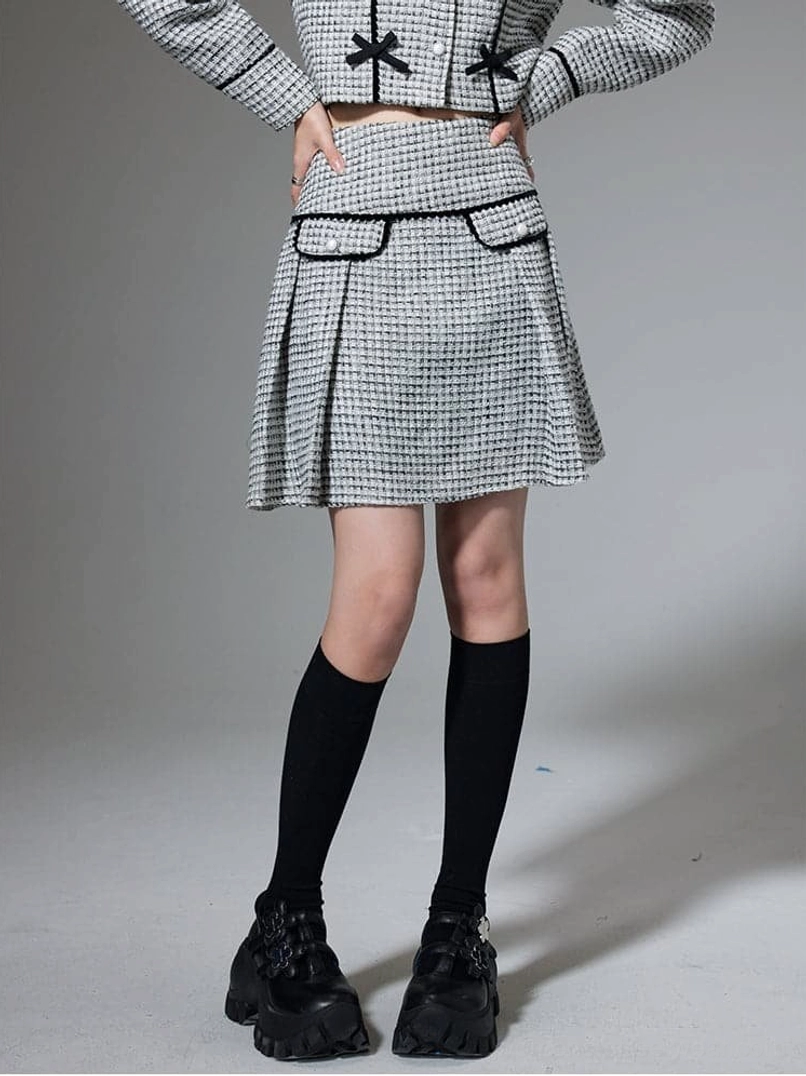 Black bow trim cropped jacket and pleated mini skirt outfit with polished Y2K fashion styling