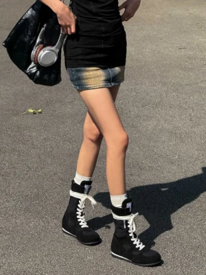 Black mid-top boxing trainer boots styled with a denim mini skirt, white crew socks, and casual Korean streetwear outfit