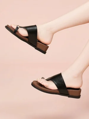 Black and brown toe ring platform slide sandals worn on foot with comfortable slip-on fit and low wedge sole