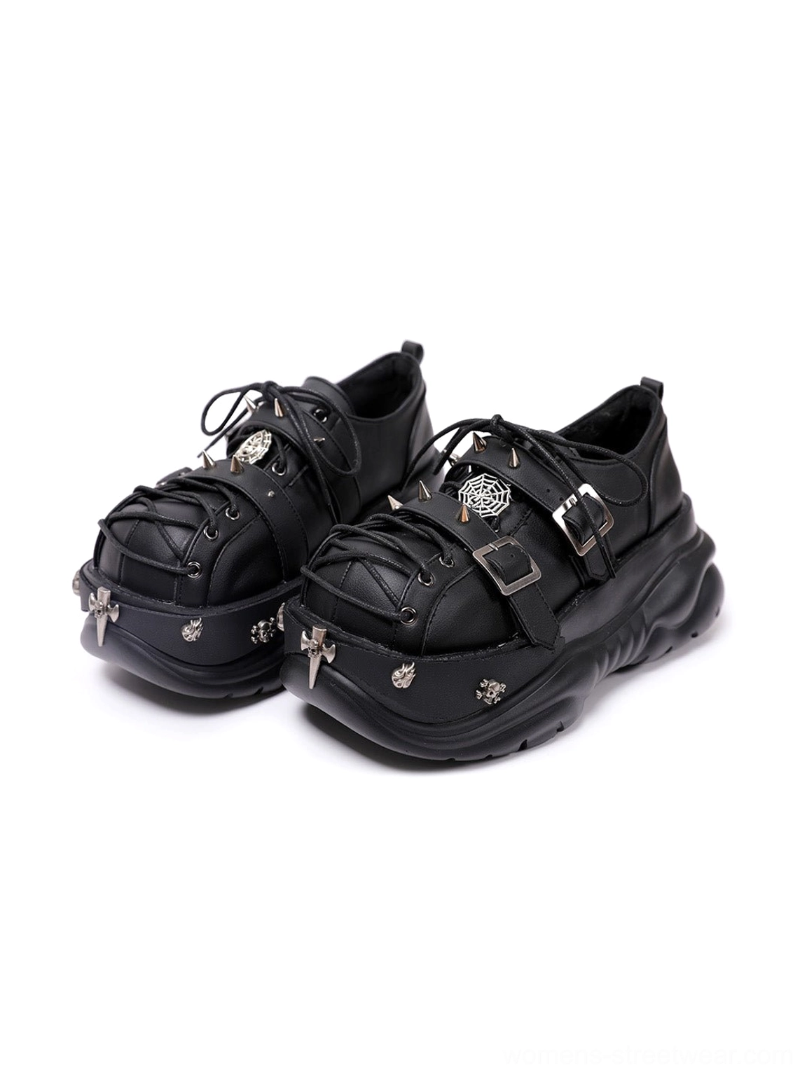 Black buckle cage chunky platform sneakers shown from the front three-quarter view with cross-inspired toe charms, layered straps, metal buckles, and oversized lug soles