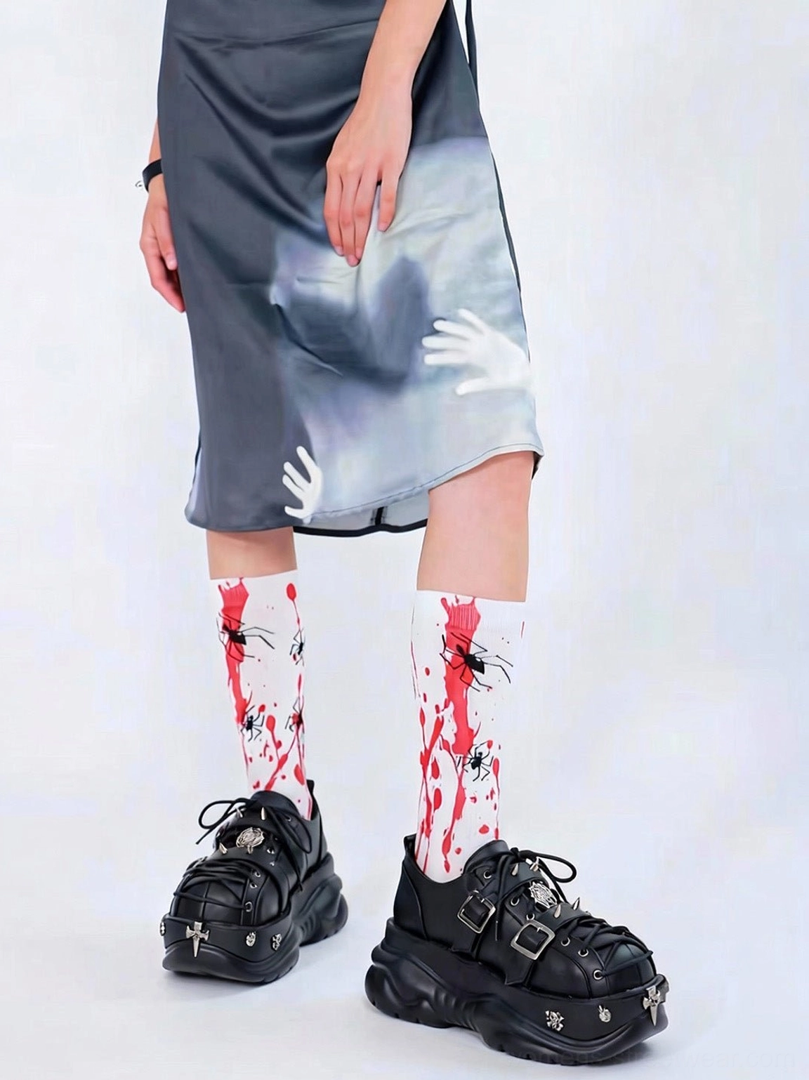 Black buckle cage punk platform sneakers worn with printed spider socks and a gray midi dress for an alternative streetwear outfit