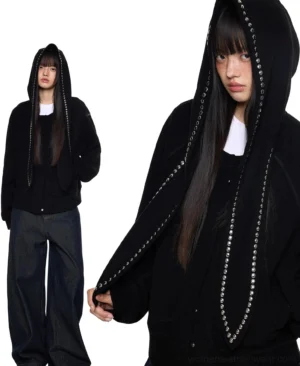 Back view of black oversized bunny ear hoodie showing long silver studded hood ears and relaxed drop shoulder streetwear fit