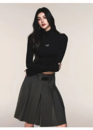 Black cropped turtleneck ribbed knit top with butterfly chest emblem and grey pleated midi skirt in Korean streetwear style