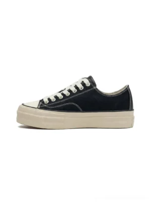 Low-top canvas platform sneaker with cork midsole, black canvas upper with white rubber toe cap and thick off-white cork midsole, left side flat product view