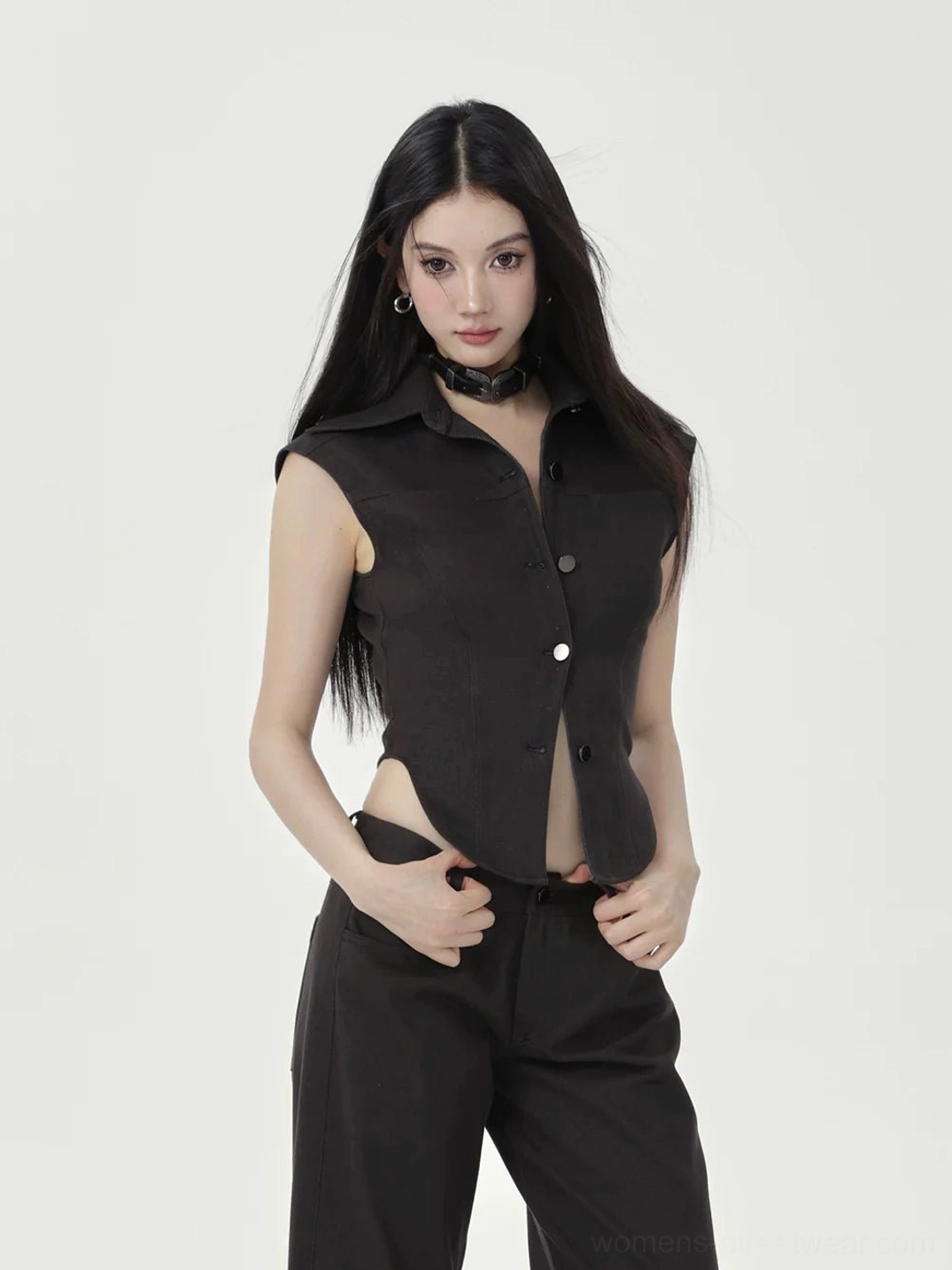 Three-quarter front view of black cap sleeve button-up crop top with exposed midriff and structured collar