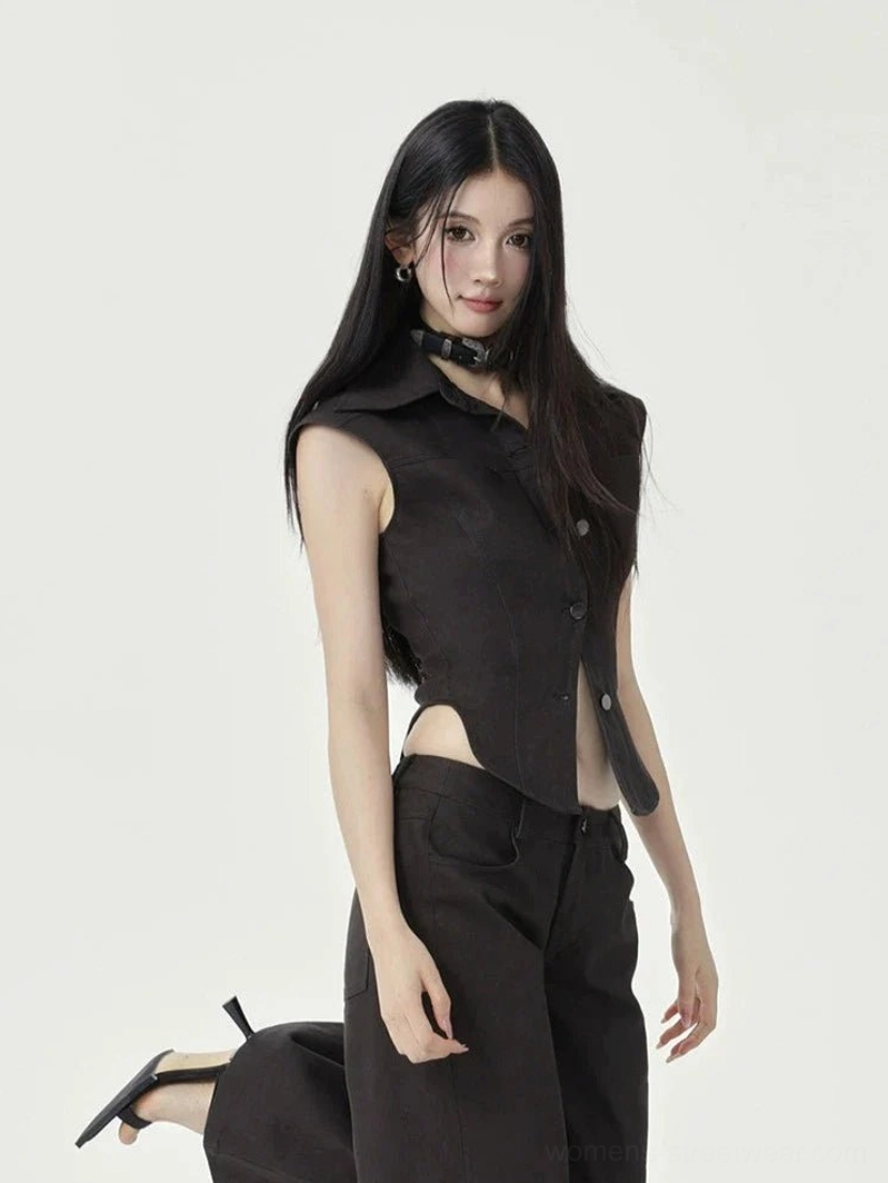 Rear three-quarter view of black cap sleeve cropped button-up top showing back slit hem and shirt collar detail