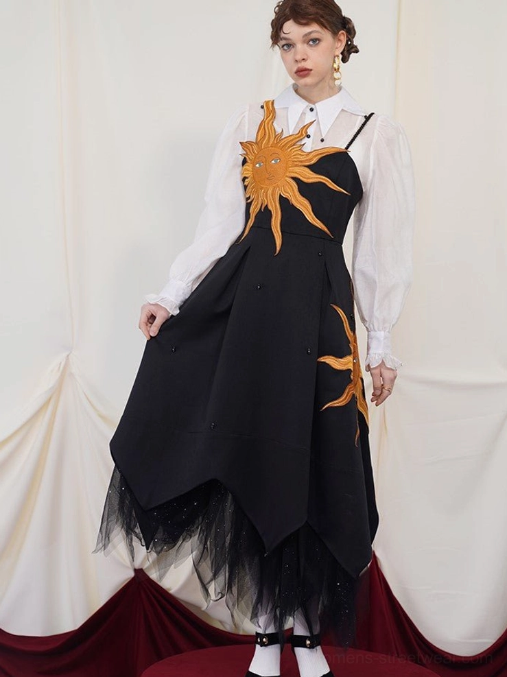 Side profile of a black celestial embroidered maxi dress with a layered tulle ruffle underlayer and pointed uneven hem