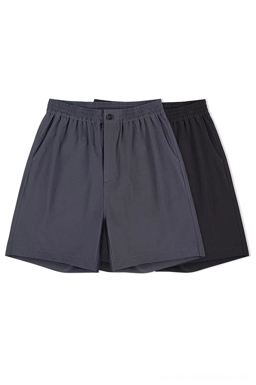 Black and charcoal gray outdoor tech shorts two-color flat lay showing matching unisex streetwear design relaxed fit and practical styling