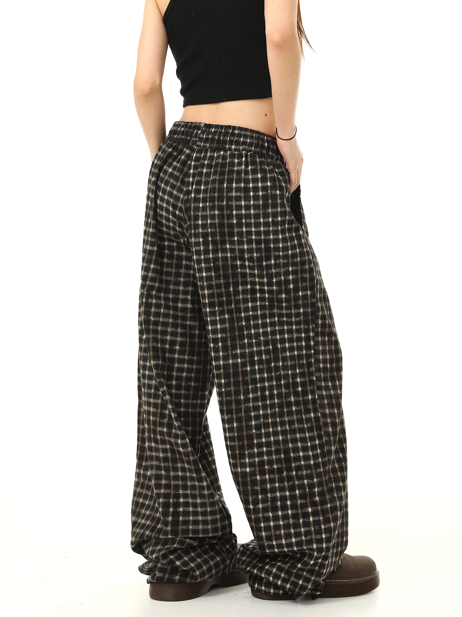 Back side view of relaxed black check wide-leg streetwear pants showing the loose silhouette pocket placement and all-over plaid pattern