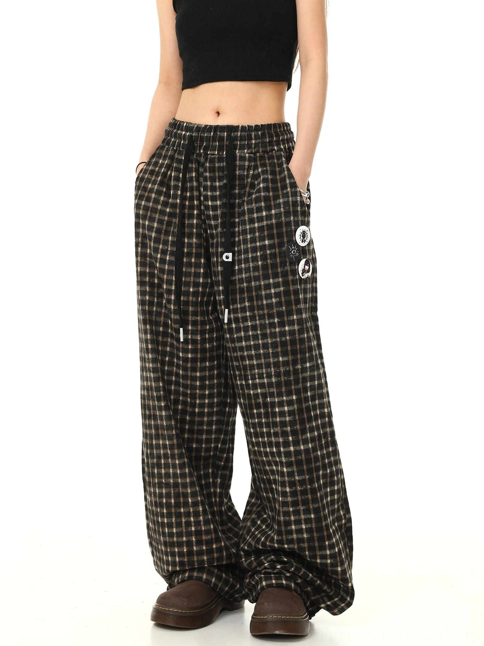 Back view of black check pattern wide-leg track pants with relaxed drape graphic badge detail and practical side pockets