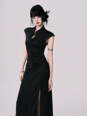 Close-up front view of black cheongsam maxi dress showing front frog-style tie fastening, ruched waist, fitted bodice, and smooth matte fabric