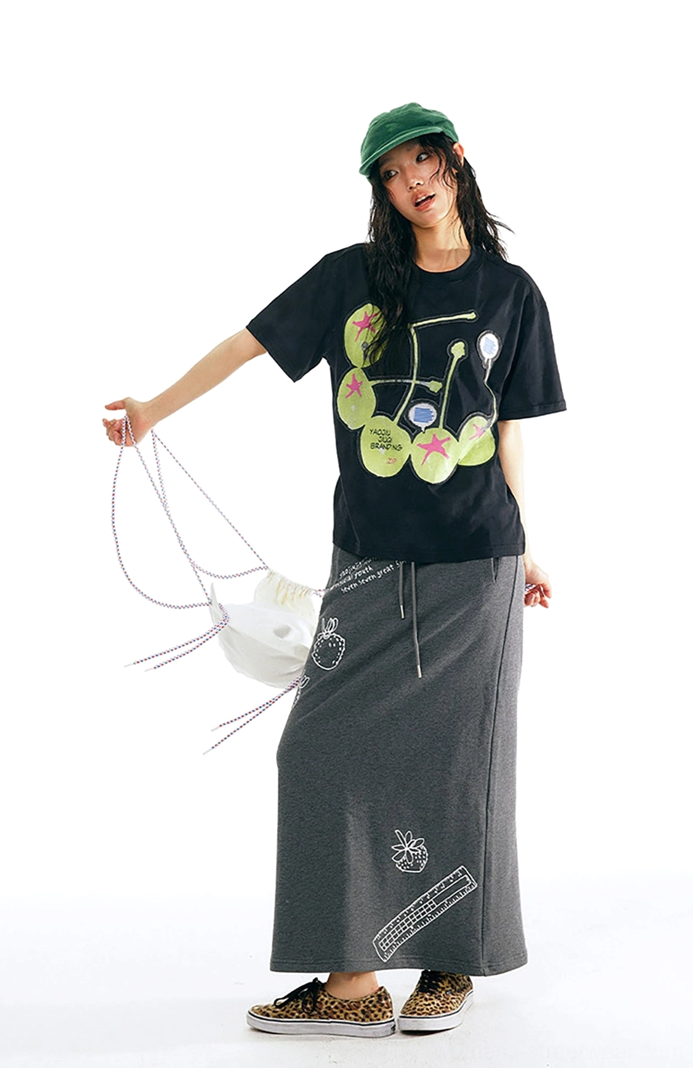 Black cherry pop graphic cotton streetwear t-shirt side profile styled with grey drawstring long skirt