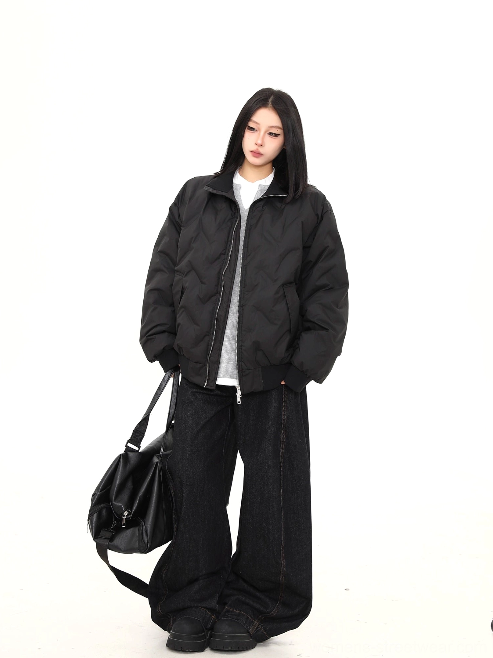Medium front view showing the stand collar, chevron stitching, matte shell, and streamlined shape of a black puffer bomber jacket