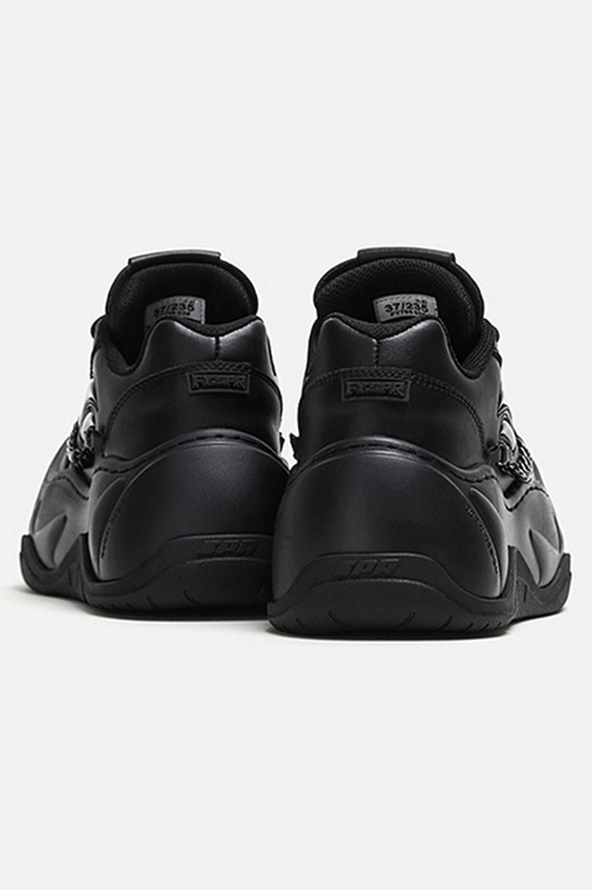 Rear view of black chunky platform chain sneakers showing heel tabs, side chain accents, and sculpted wave rubber outsole