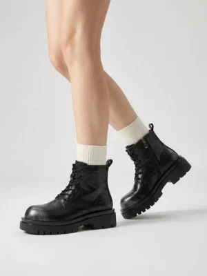 Black chunky platform combat boots styled with white crew socks showing classic lace-up front and rugged lug sole