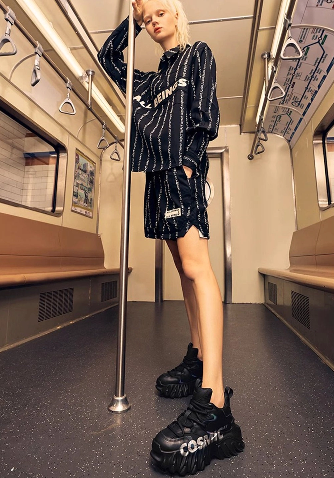 Black sculpted sole platform shoes styled with monochrome loungewear in a subway cabin