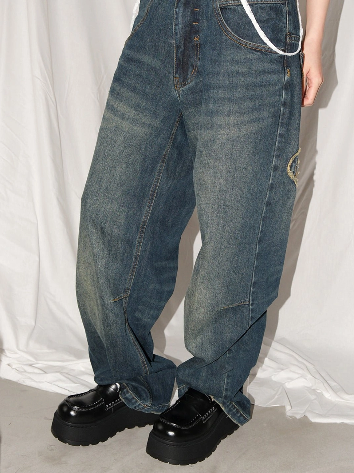 Women's black chunky platform loafers styled with vintage wide-leg jeans to show the elevated Y2K streetwear effect