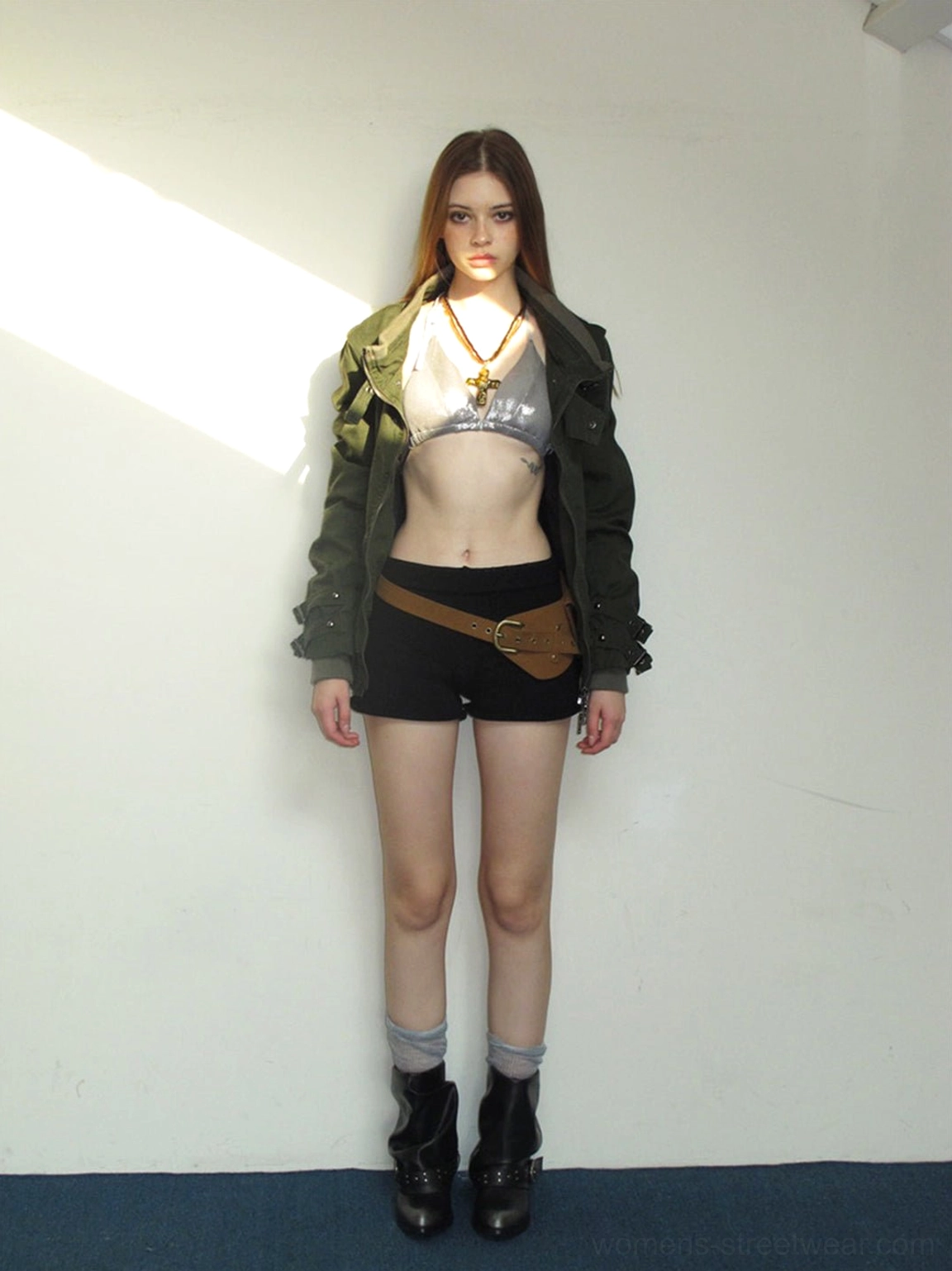 Full body model outfit with black chunky pointed toe ankle boots green jacket and black shorts