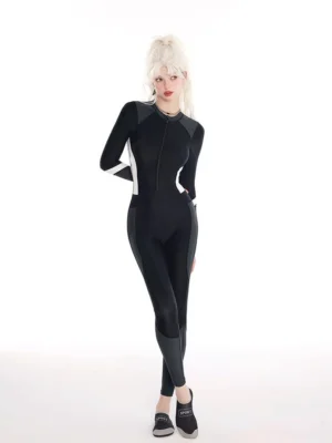 Three-quarter front view of black long-sleeve one-piece rash guard swim jumpsuit with charcoal legs and white sleeve stripe accents