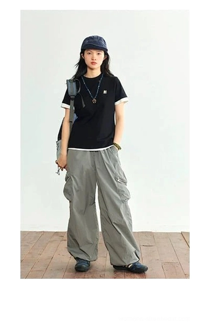 Black minimalist logo tee with contrast white crew neck hem detail full body front view gray cargo pants